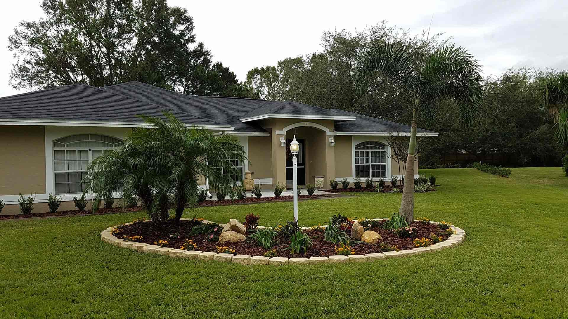 Beautifully cut front lawn in Lakeland, FL by Tropical Temptations Landscaping.
