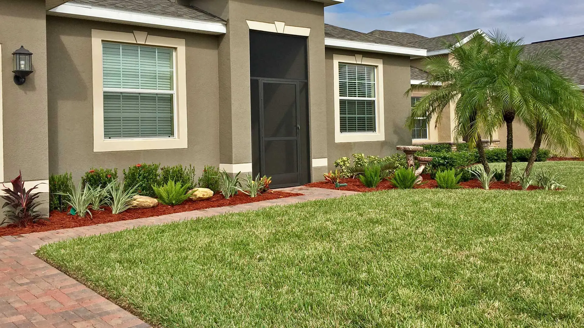 Landscaping design and installation with new plant, shrubs, tree, flowers, and mulch.