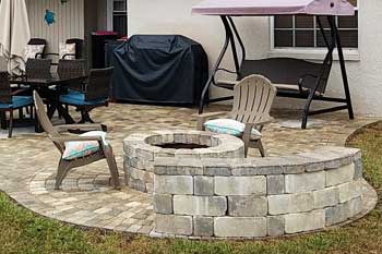 Custom fire pit designed and built by Tropical Temptations Landscaping at a Auburndale, FL home.